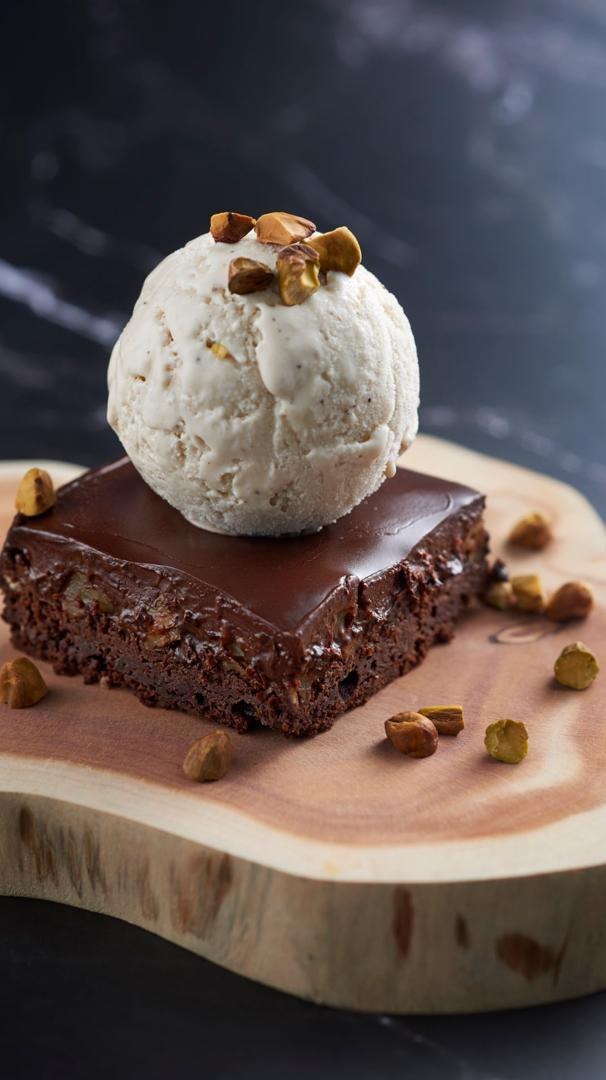 A scoop of Loving Café pistachio ice cream on a brownie