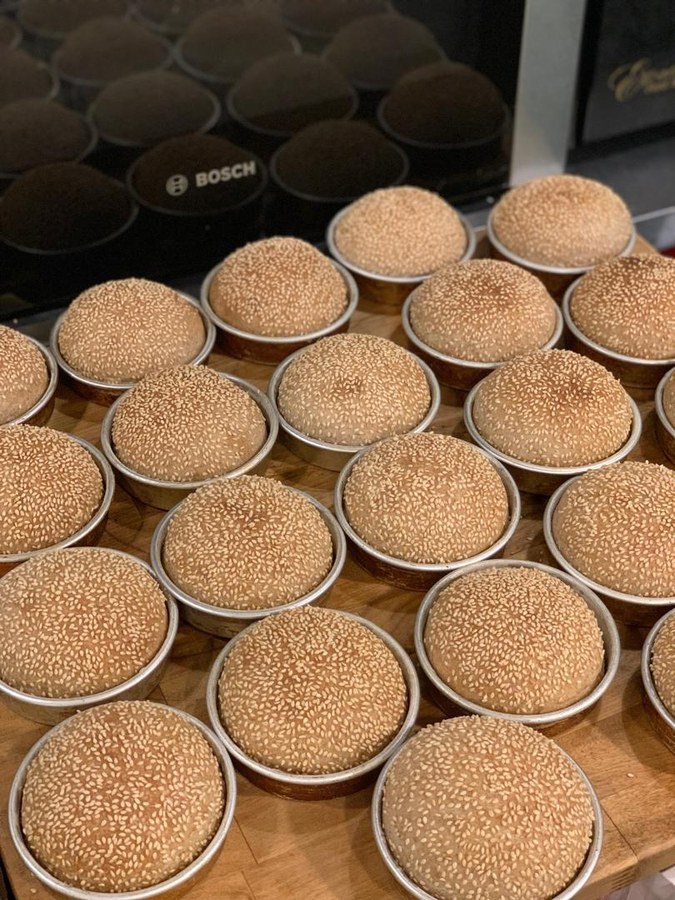 Trays of handmade sourdough buns before baking